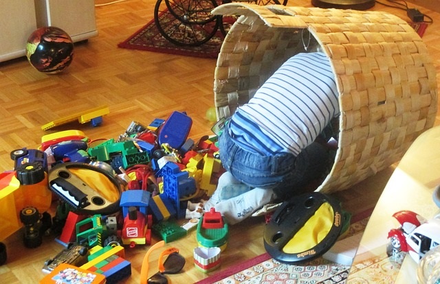 Child in a basket surrounded by toys.