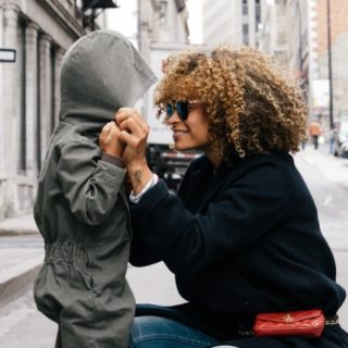 Mom bending down to eye level with a child.