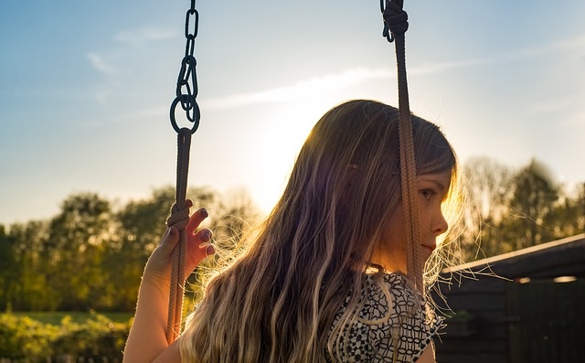 A child swinging on the swing.