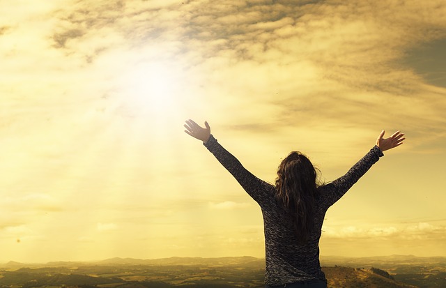 Woman raising arms in sunshine