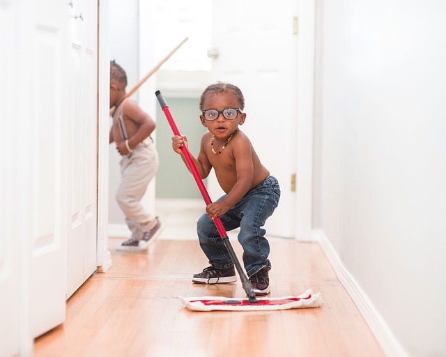 A little boy mopping the floor.