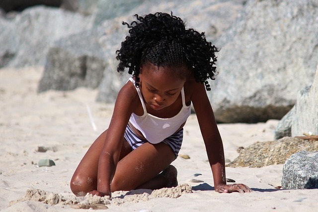 A girl playing in sand.