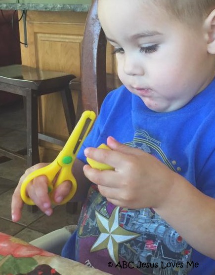 Child cutting play dough.