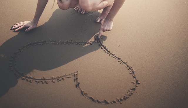 Heart drawn in sand. Love is and does...