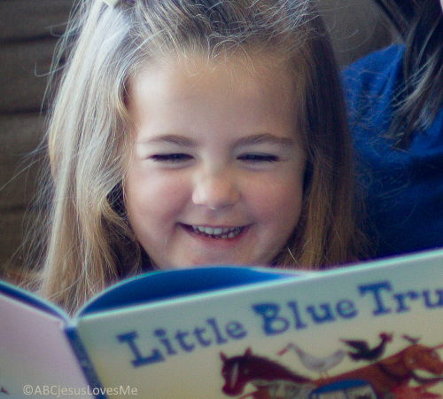 Little girl reading the Little Blue Truck book.