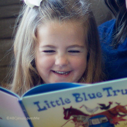 Little girl reading the Little Blue Truck book, a must-read book.