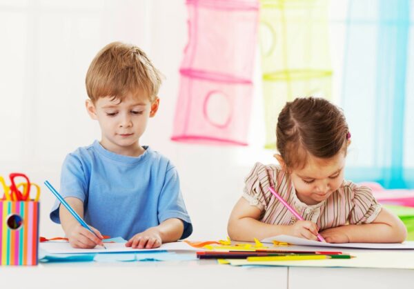 Boy and girl coloring with colored pencils.