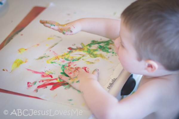 Little boy fingerpainting.