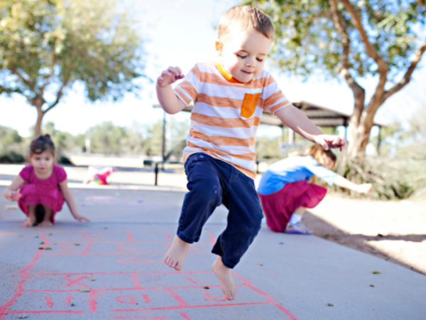 Little boy playing hopscotch.  