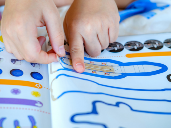 Child playing with sticker book during church.