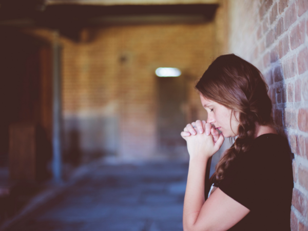 Woman standing in a church praying.