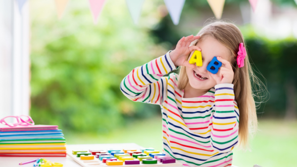 A little girl with a letter puzzle.