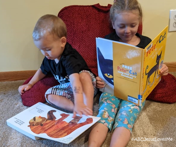 Preschool brother and sister reading books.