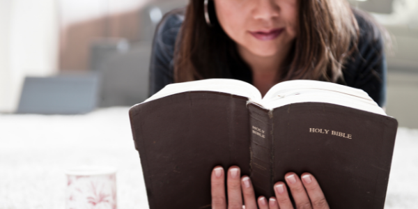 Woman reading her Bible and praying Scripture.