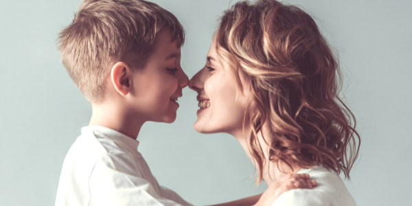 Mom and son smiling at each other.