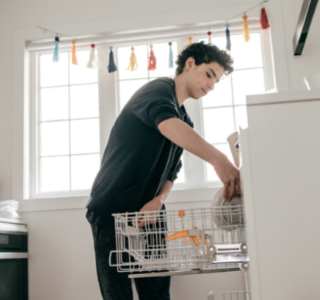 Teen loading the dishwasher.