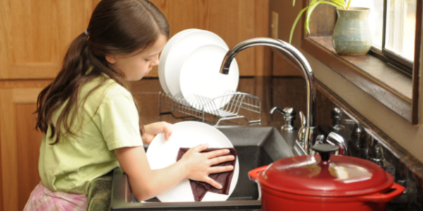 Girl doing the dishes as her chore.