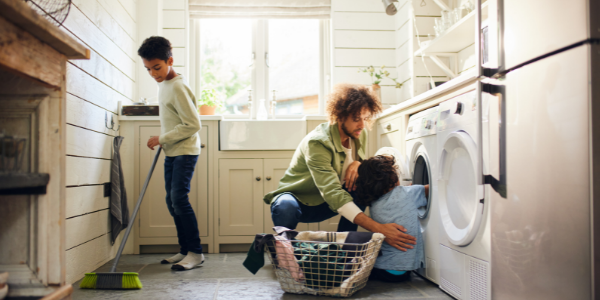 Dad helping children to laundry chores.