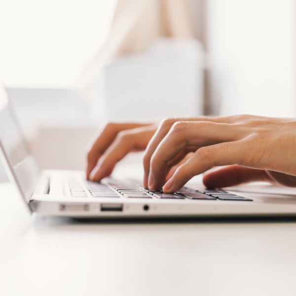 Woman typing on a laptop.