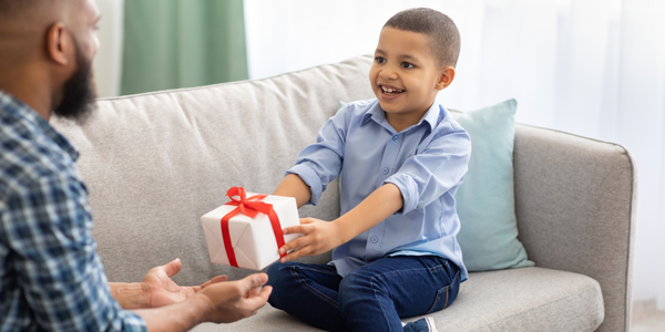 A boy giving a gift to his dad.