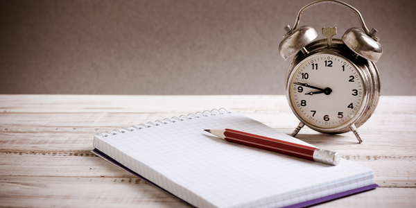 Clock with a journal and pencil.