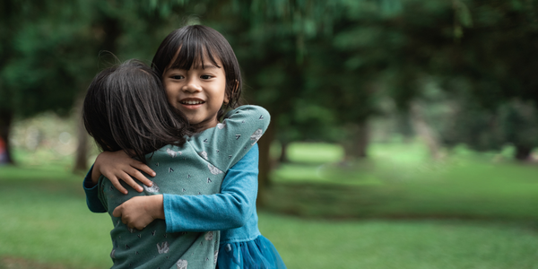 Two young girls hugging.