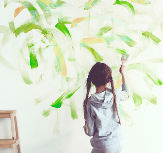 Child expressing herself by painting on the walls.