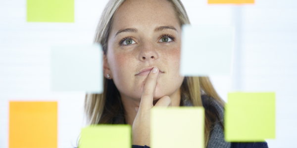 Woman looking at post-it notes deciding options.