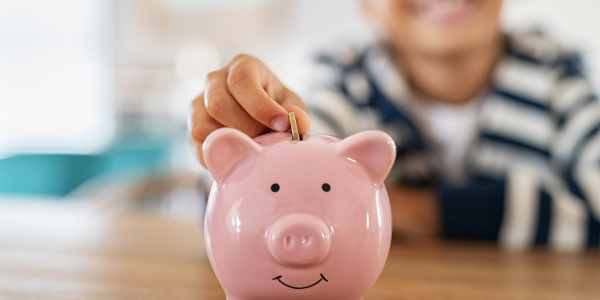 Child putting money into a piggy bank for missions.