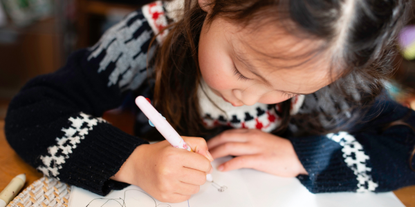 Child writing a letter to missionaries.