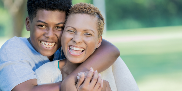 Teen hugging his mom.