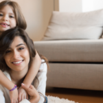 Child hugging mom from the back.