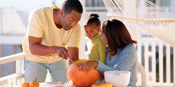 A family carving a pumpkin.