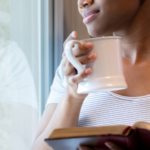 Woman holding her Bible and coffee while reflecting.