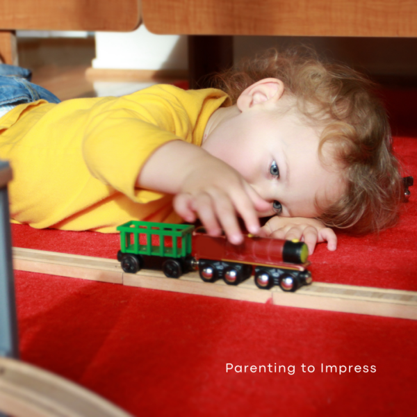 Child independently playing with a toy train.