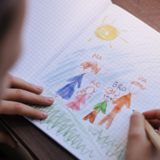 Child drawing a picture of their family.