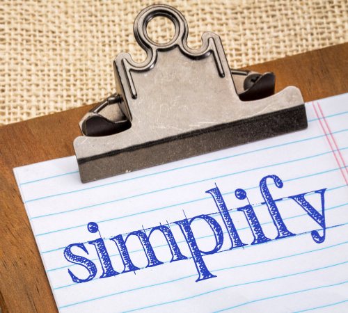 Clipboard with a paper saying, "Simplify"