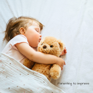 Child sleeping while holding a teddy bear.