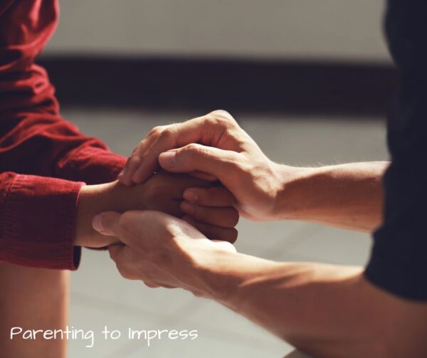 a mom holding hands with another mom, offering encouragement