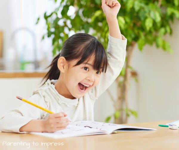 child smiling with arm raised, celebrating her accomplishment