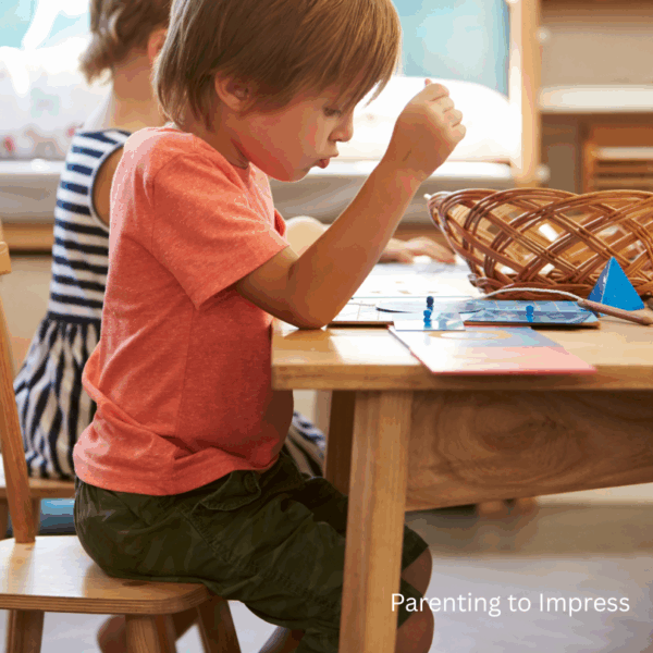 A preschooler sitting at a child-sized table.