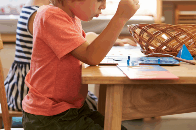 A preschooler sitting at a child-sized table.