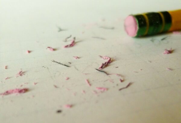 Eraser shavings on a piece of paper, with an eraser laying next to it. (symbolizing forgiveness we seek when we apologize)