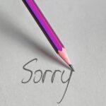 a pencil writing the word "sorry"