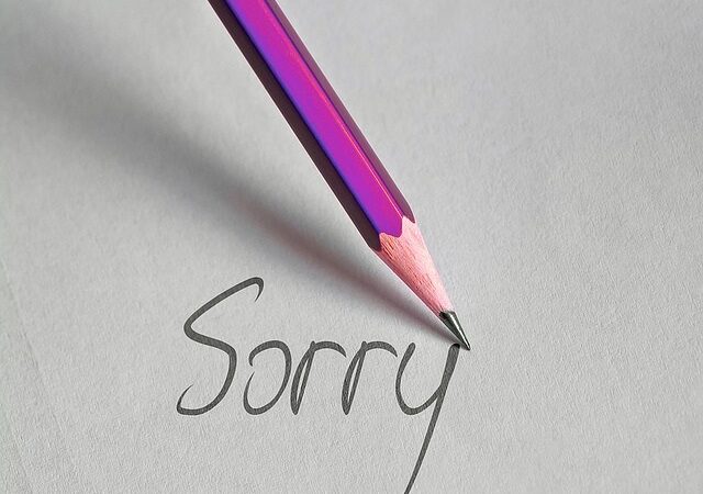 a pencil writing the word "sorry"
