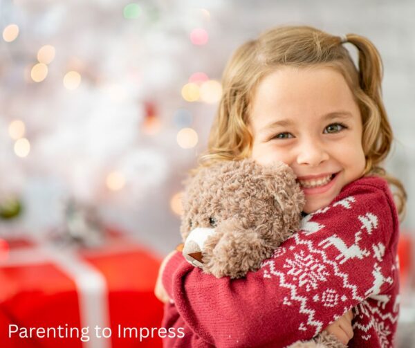 Happy calm child on Christmas, hugging teddy bear

