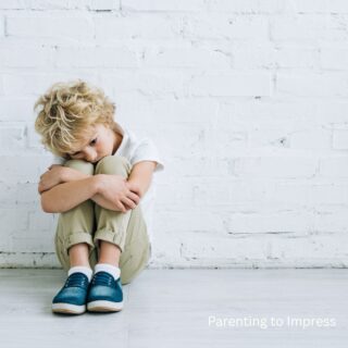 A young boy upset, sitting on the ground.
