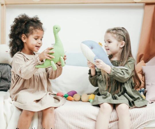 Two girls playing with stuffed animals, role playing.